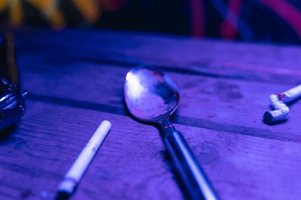 pexels-photo-7230218-7230218 Dramatic depiction of potential drug use with spoon and cigarette in moody lighting.